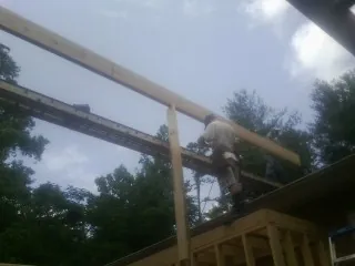 Carpenter setting a ridge beam over a new addition frame — Ice Dam Removal by Roofing Brothers in Island Heights