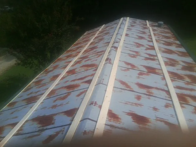 Rusted metal roof panels with new wood purlins before replacement — Storm Damage Roof Repair in Island Heights by Roofing Brothers