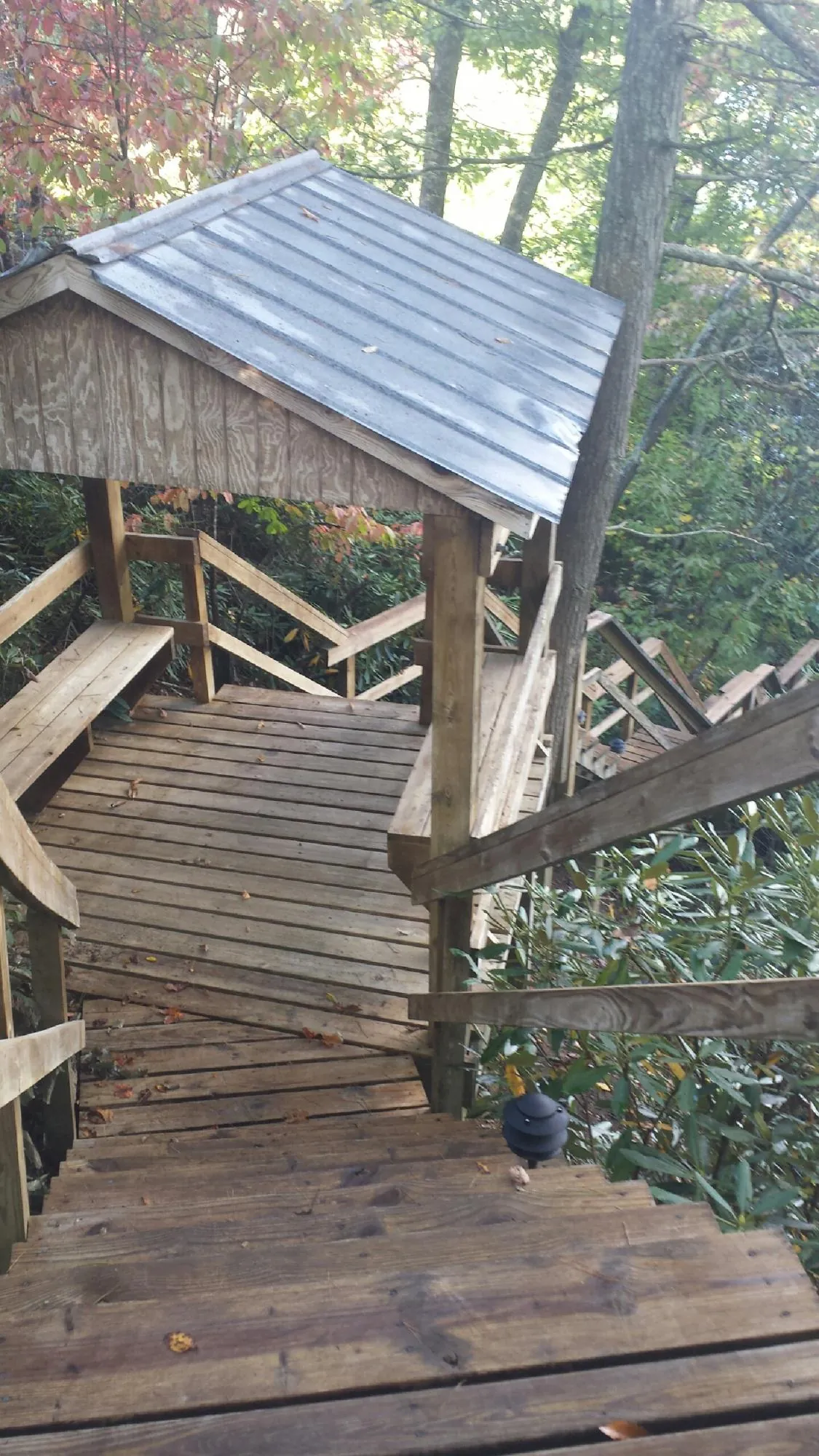 Metal roofed shelter over wooden steps on a wooded walkway — Skylight Repair & Installation work by our crew in Island Heights
